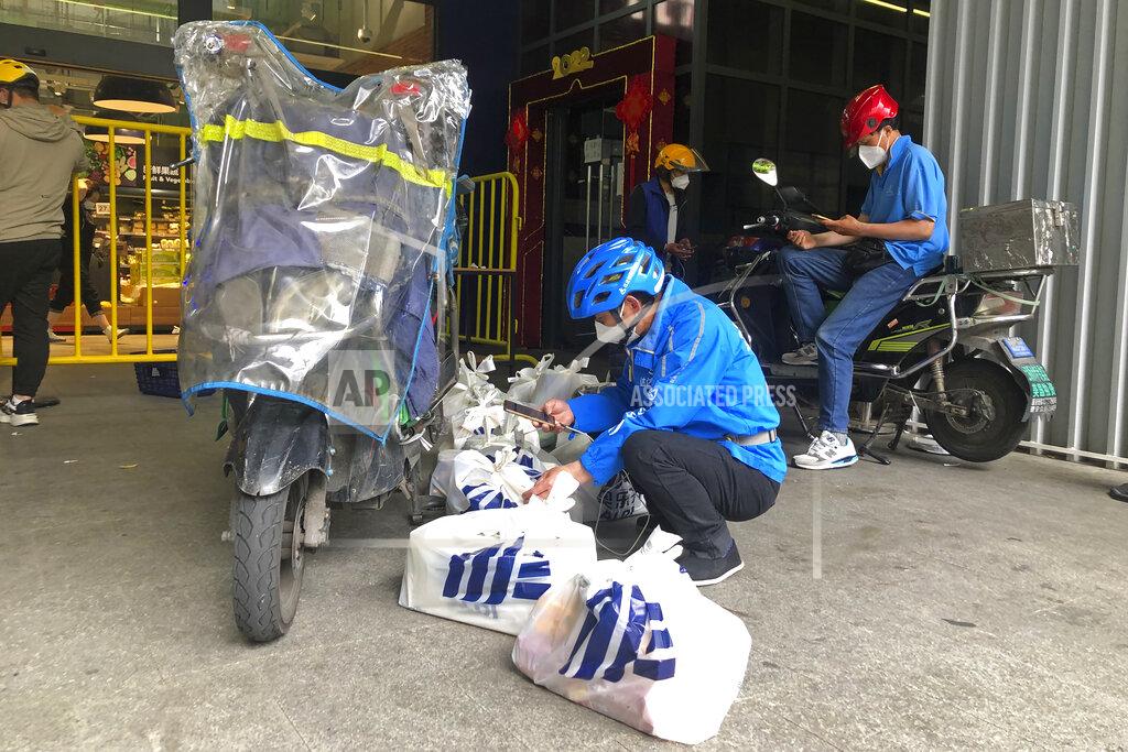 Chen Si Delivery workers sort out bags of groceries outside a supermarket in Shanghai, China, Monday, May 23, 2022. Shanghai reported 480,000 people were still confined to their homes due to COVID-19 precautions, while 1.59 million were permitted to move around their neighborhoods and 21.2 million were under lighter restrictions. (AP Photo/Chen Si)