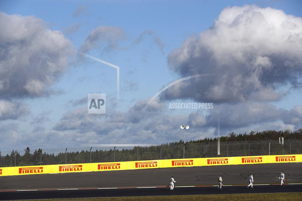 Matthias Schrader Marshals clean the track prior to the start of the third practice session for the Eifel Formula One Grand Prix at the Nuerburgring racetrack in Nuerburg, Germany, Saturday, Oct. 10, 2020. The Germany F1 Grand Prix will be held on Sunday. (AP Photo/Matthias Schrader, Pool)