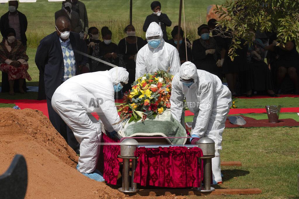 Jerome Delay Pallbearers wearing full PPE suits lower in the grave the casket containing the remains of Benedict Somi Vilakasi for his burial ceremony at the Nasrec Memorial Park outside Johannesburg Thursday, April 16, 2020. Vilakasi, a Soweto coffee shop manager, died of Covid-19 infection in a Johannesburg hospital Sunday April 12 2020. South Africa is under a strict five-week lockdown in a effort to fight the Coronavirus pandemic.(AP Photo/Jerome Delay)