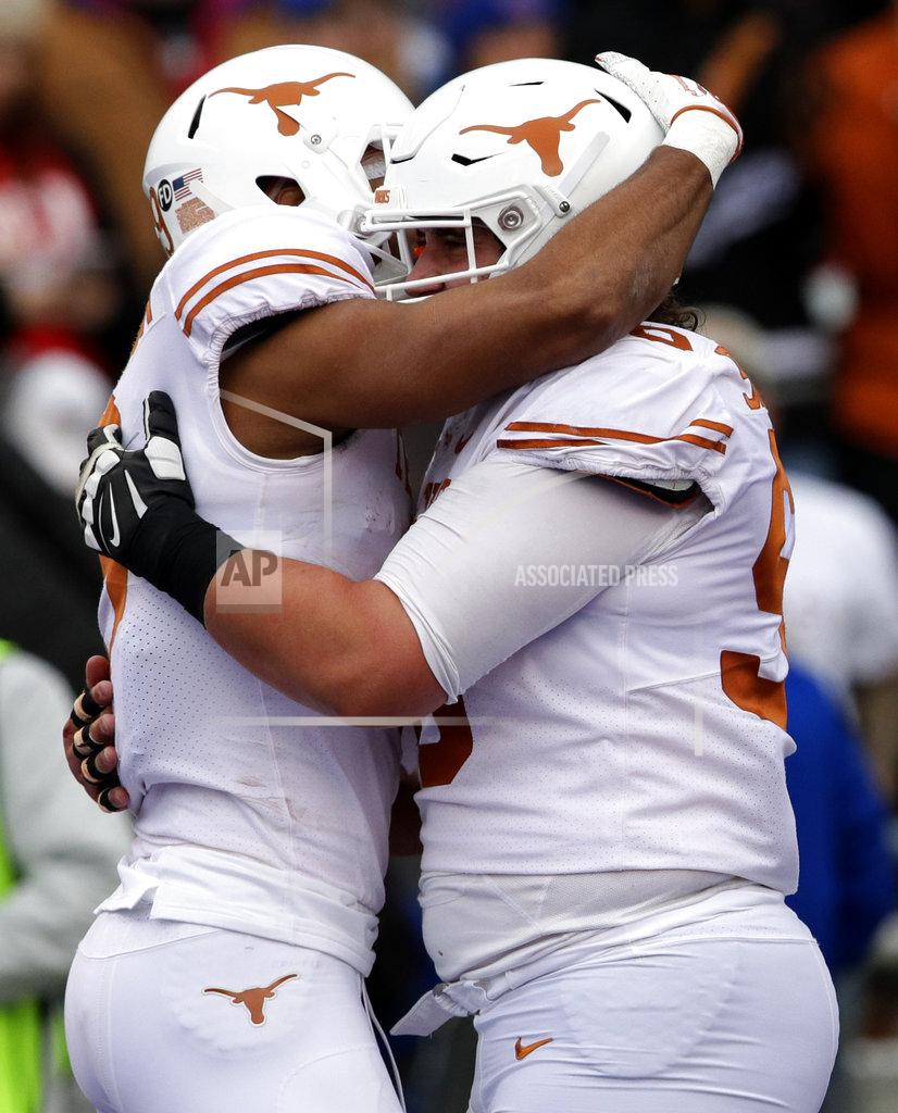 Orlin Wagner Texas wide receiver Collin Johnson, left, is congratulated by teammate Zach Shackelford, right, after a touchdown during the first half of an NCAA college football game against Kansas in Lawrence, Kan., Friday, Nov. 23, 2018. (AP Photo/Orlin Wagner)