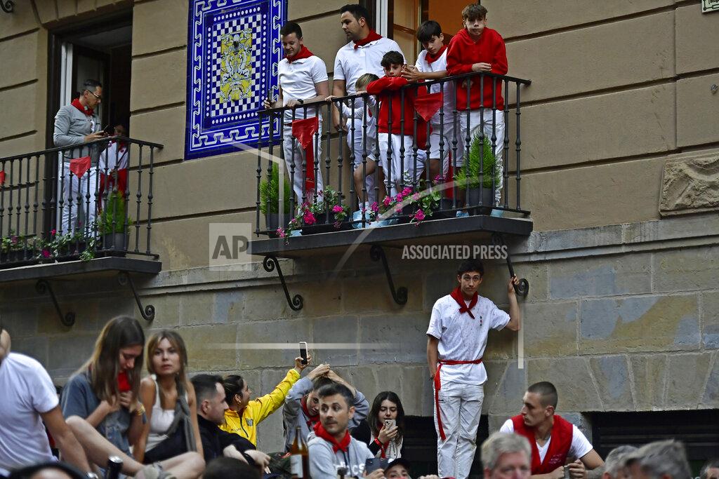 Alvaro Barrientos People stand on balconies and wooden barriers below to watch the running of the bulls on the first day at the San Fermin Festival in Pamplona, northern Spain, Thursday, July 7, 2022. Revelers from around the world flock to Pamplona every year for nine days of uninterrupted partying in Pamplona's famed running of the bulls festival which was suspended for the past two years because of the coronavirus pandemic. (AP Photo/Alvaro Barrientos)