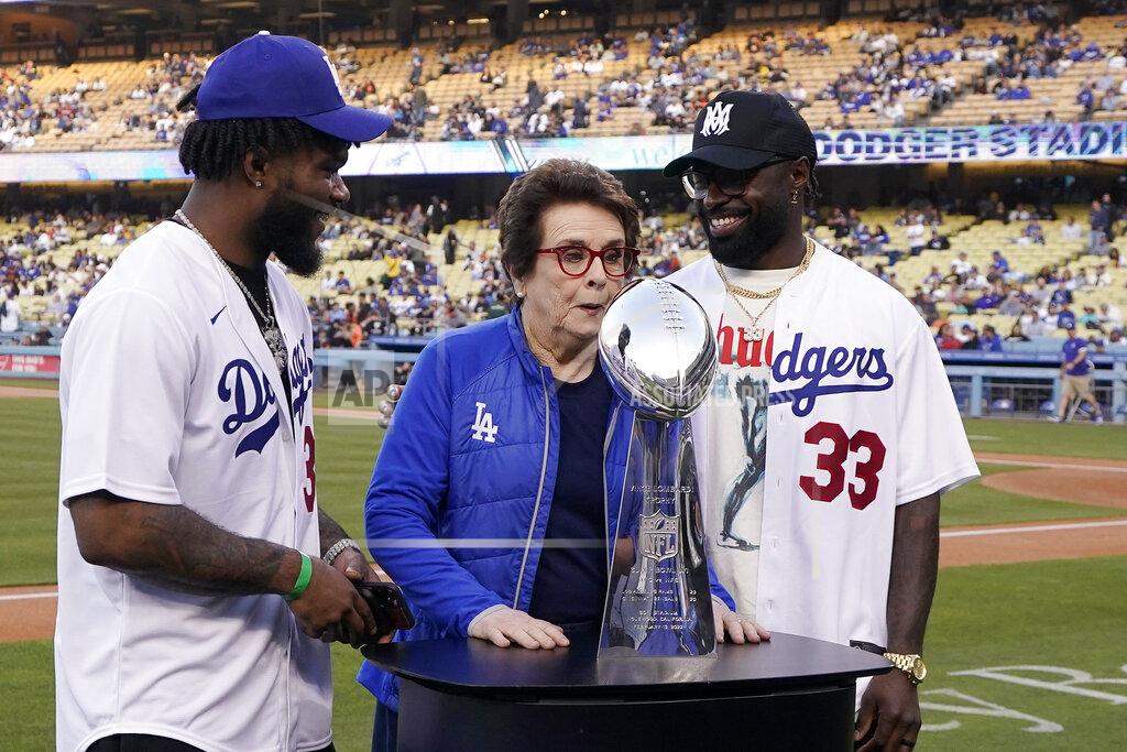 Mark J. Terrill Los Angeles Rams running back Cam Akers, left, and safety Nick Scott, right, pose behind the the Vince Lombardi Trophy with tennis great Billie Jean King during a visit by members of the Rams prior to a baseball game between the Los Angeles Dodgers and the San Francisco Giants Tuesday, May 3, 2022, in Los Angeles. (AP Photo/Mark J. Terrill)