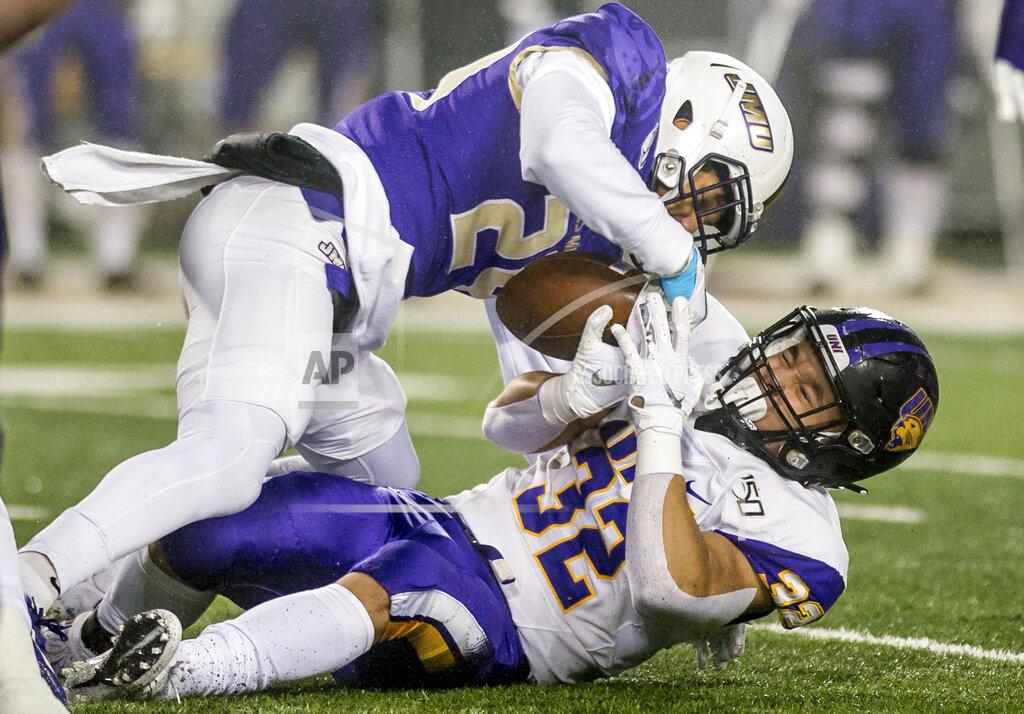 Daniel Lin James Madison safety D'Angelo Amos (24) strips the ball away from Northern Iowa running back Tyler Hoosman (32) for a fumble during the first half of a quarterfinal game in the NCAA college Football Championship Subdivision playoffs in Harrisonburg, Va., Friday, Dec. 13, 2019. (Daniel Lin/Daily News-Record via AP)