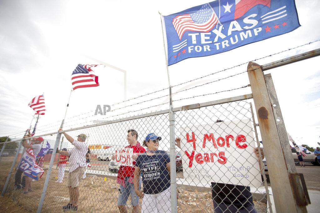 Ben Powell Standing at the fence, supporters of President Donald Trump display flags and signs as they wait for Air Force One to land Wednesday afternoon July 29, 2020 at Midland International Air and Space Port in Midland Texas. (Ben Powell/Odessa American via AP)