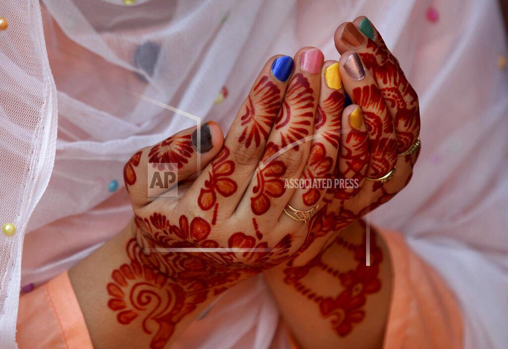 K.m. Chaudary A woman, her hands decorated with traditional henna, prays during Eid al-Fitr prayer at historical Badshahi mosque in Lahore, Pakistan, Sunday, May 24, 2020. Millions of Muslims across the world are marking a muted and gloomy holiday of Eid al-Fitr, the end of the fasting month of Ramadan _a usually joyous three-day celebration that has been significantly toned down as coronavirus cases soar. (AP Photo/K.M. Chaudary)