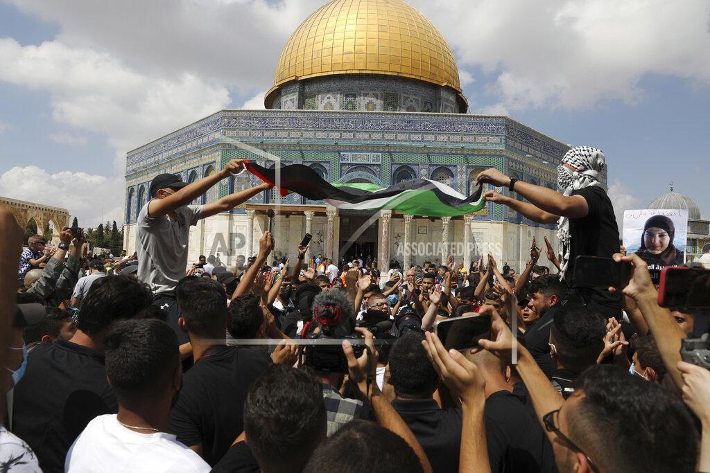 Mahmoud Illean Protesters wave a Palestinian flag and one in the crowd holds a spoon, which has become a symbol celebrating the six Palestinian prisoners who tunneled out of Gilboa Prison, after Friday prayers at the Dome of the Rock Mosque in the Al Aqsa Mosque compound in in the Old City of Jerusalem, Friday, Sept. 10, 2021. (AP Photo/Mahmoud Illean)