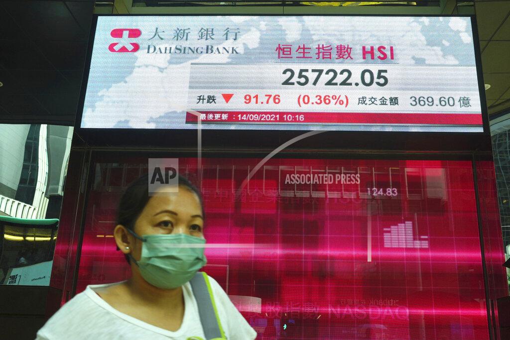 Vincent Yu A woman walks past a bank's electronic board showing the Hong Kong share index at Hong Kong Stock Exchange in Hong Kong Tuesday, Sept. 14, 2021. Asian stock markets were mixed Tuesday as investors waited for an update on U.S. inflation that has been stronger than expected. (AP Photo/Vincent Yu)