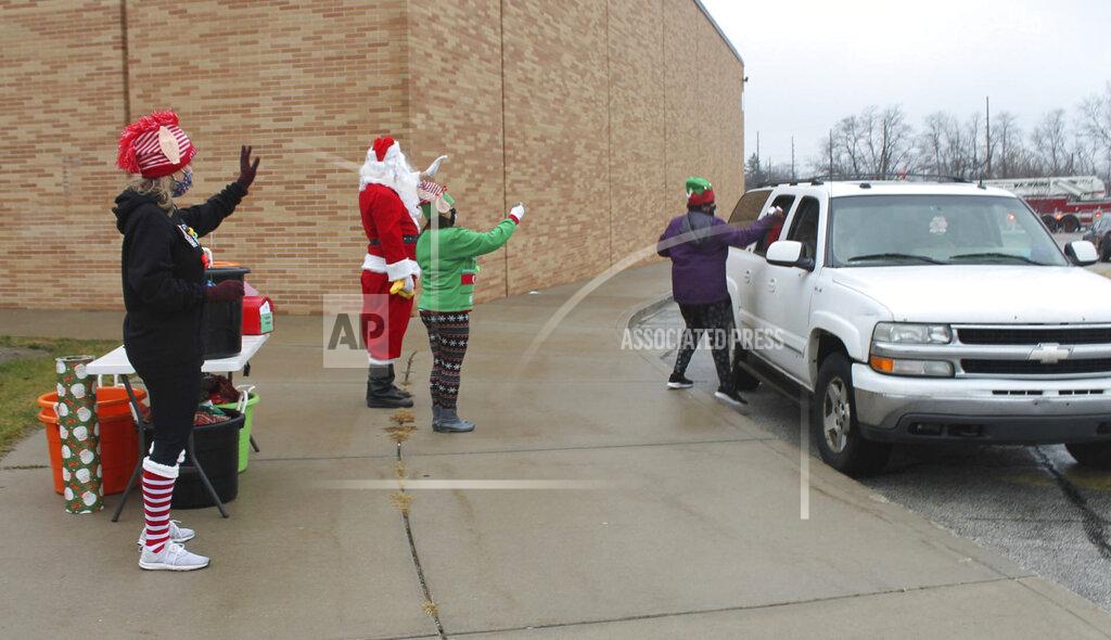 Kelley Smith Santa Claus and his helpers at the La Porte County YMCA's Elston Branch in Michigan City, Ind., braved the rain to spread some holiday cheer on the morning of Saturday, Dec. 12, 2020, when they hosted a socially distanced drive-thru style meet and greet with Santa. Each child was gifted a stocking filled with toys and treats. Kids also dropped off their letters to Santa, and the crew danced to classic holiday tunes in between visitors. (Kelley Smith/The News Dispatch via AP)