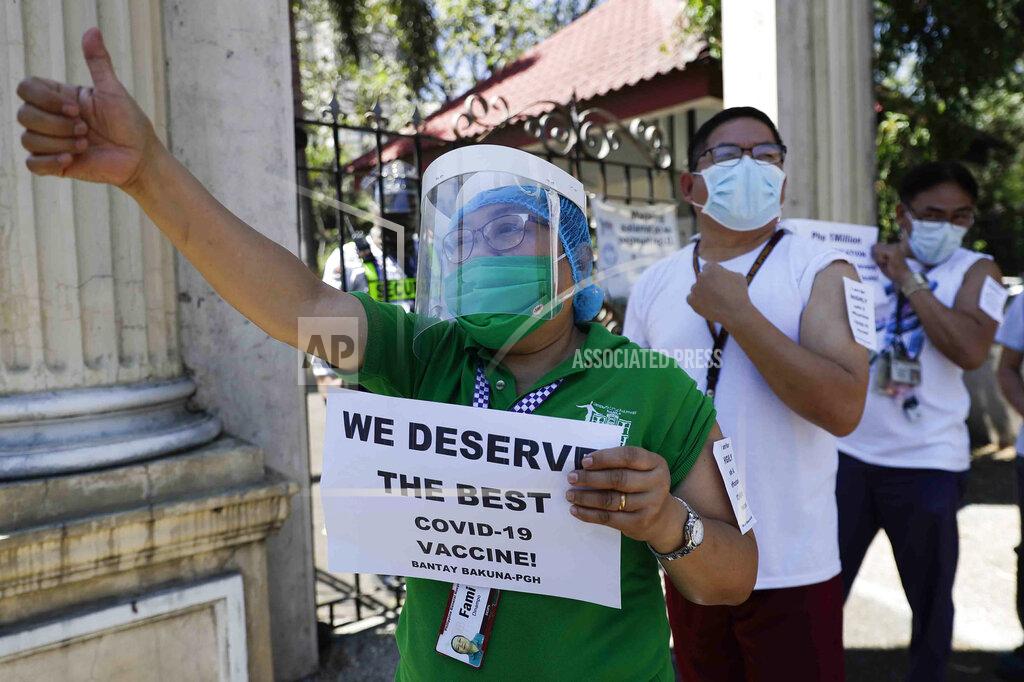 Aaron Favila FILE - In this Friday, Feb. 26, 2021 file photo, a health worker wearing a face mask and shield holds a sign as she and others call on the government to give them a vaccine with the safest, highest efficacy and effectivity during a a protest outside the Philippine General Hospital in Manila, Philippines. The group is opposing a plan by the government to have health workers vaccinated with China's Sinovac. (AP Photo/Aaron Favila)