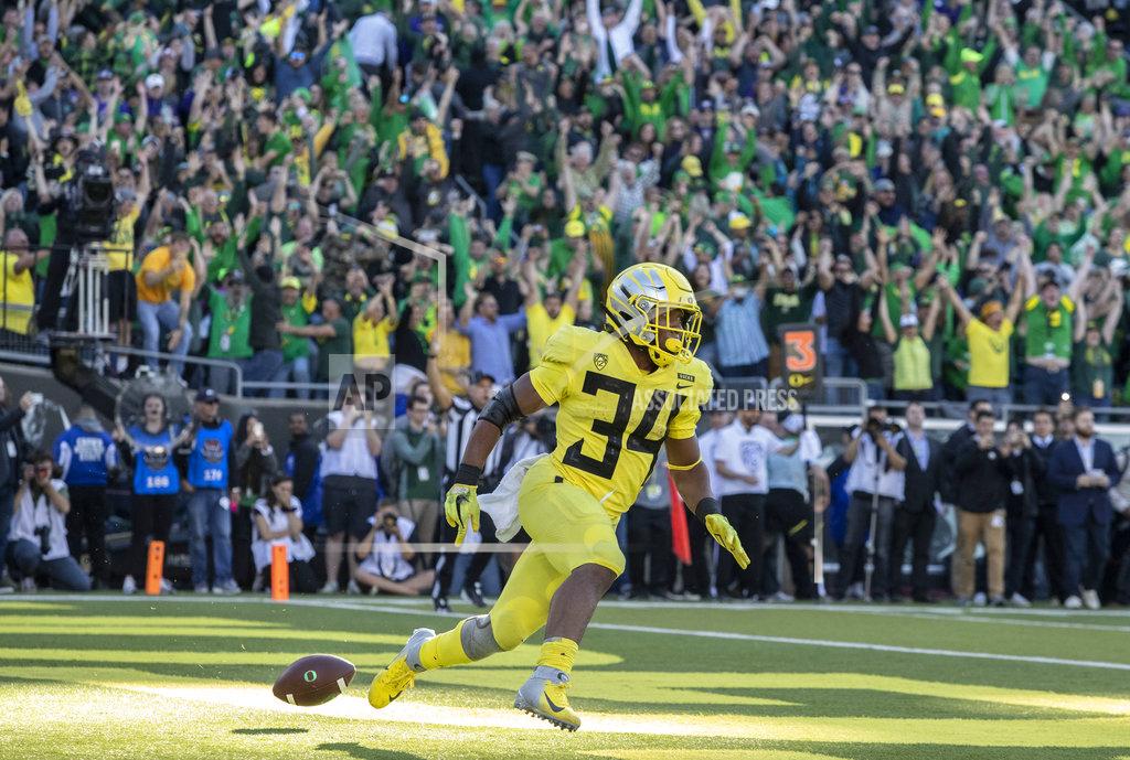 Oregon running back CJ Verdell (34), scores the winning touchdown in overtime to beat Washington 30-27 in an NCAA college football game in Eugene, Ore., Saturday, Oct. 13, 2018. (AP Photo/Thomas Boyd)