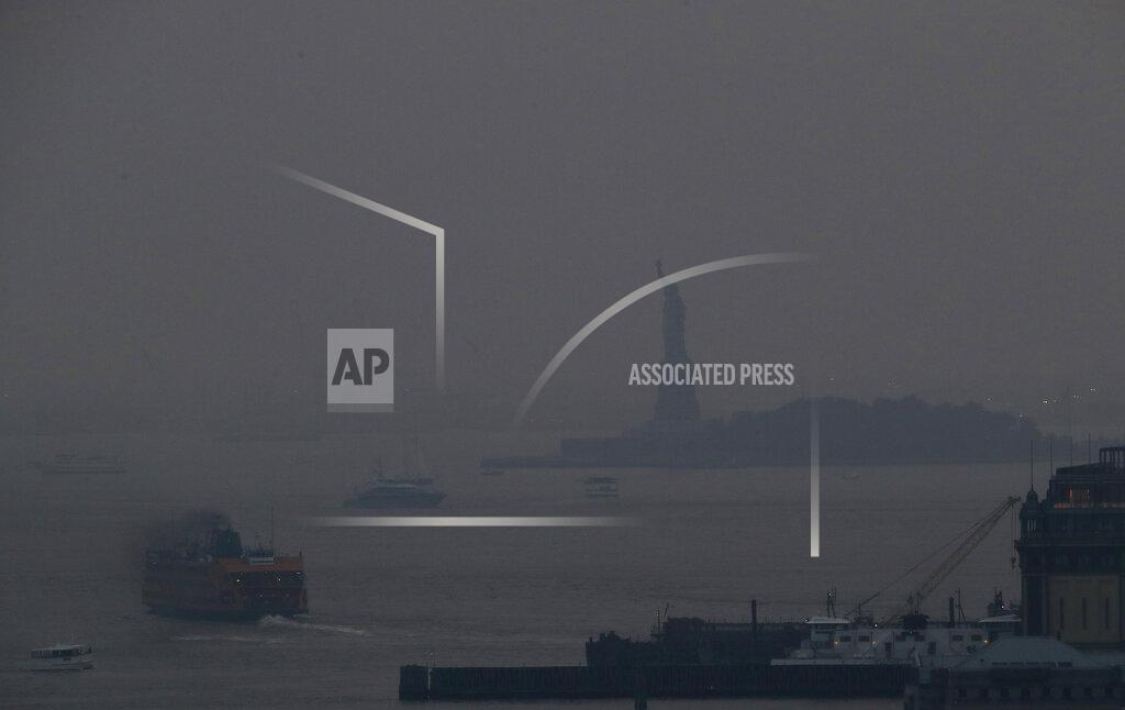 Julie Jacobson The Staten Island Ferry departs from the Manhattan terminal through a haze of smoke with the Statue of Liberty barely visible, Tuesday, July 20, 2021, in New York. Wildfires in the American West, including one burning in Oregon that's currently the largest in the U.S., are creating hazy skies as far away as New York as the massive infernos spew smoke and ash into the air in columns up to six miles high. (AP Photo/Julie Jacobson)