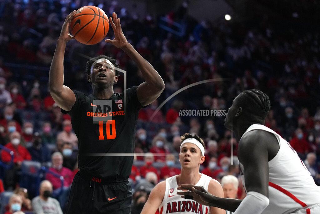 Rick Scuteri Oregon State forward Warith Alatishe (10) shoots as Arizona's Kerr Kriisa and Oumar Ballo, right, watch during the first half of an NCAA college basketball game Thursday, Feb. 17, 2022, in Tucson, Ariz. (AP Photo/Rick Scuteri)