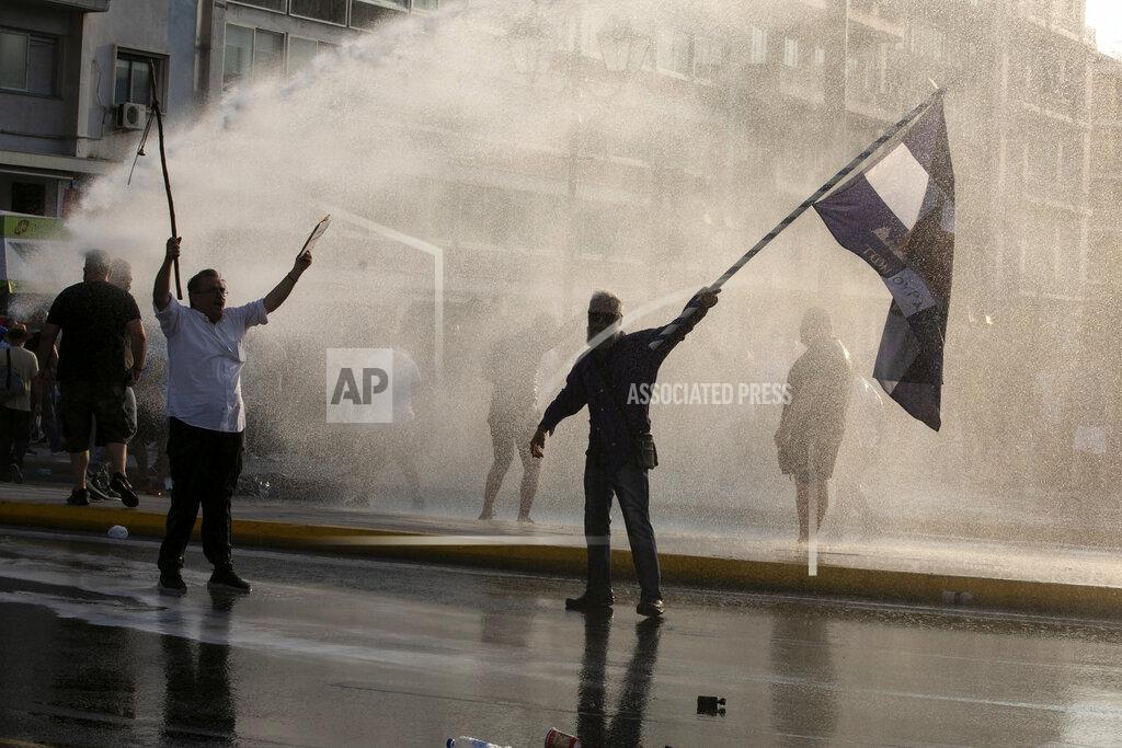 Yorgos Karahalis Greek police use tear gas and water cannons to disperse anti-vaccine protesters during a rally at Syntagma square, central Athens, on Wednesday, July 21, 2021. Thousands of people protested against Greek government's measures to curb rising COVID-19 infections and drive up vaccinations in the country where almost 50% of Greeks and country residents have received at least one dose of the vaccine. (AP Photo/Yorgos Karahalis)