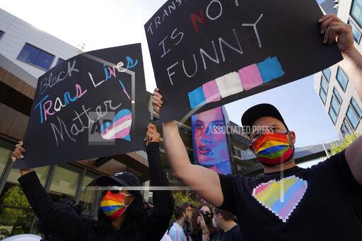 People protest outside the Netflix building on Vine Street in the Hollywood section of Los Angeles, Wednesday, Oct. 20, 2021. Critics and supporters of Dave Chappelle's Netflix special and its anti-transgender comments gathered outside the company's offices Wednesday. (AP Photo/Damian Dovarganes)