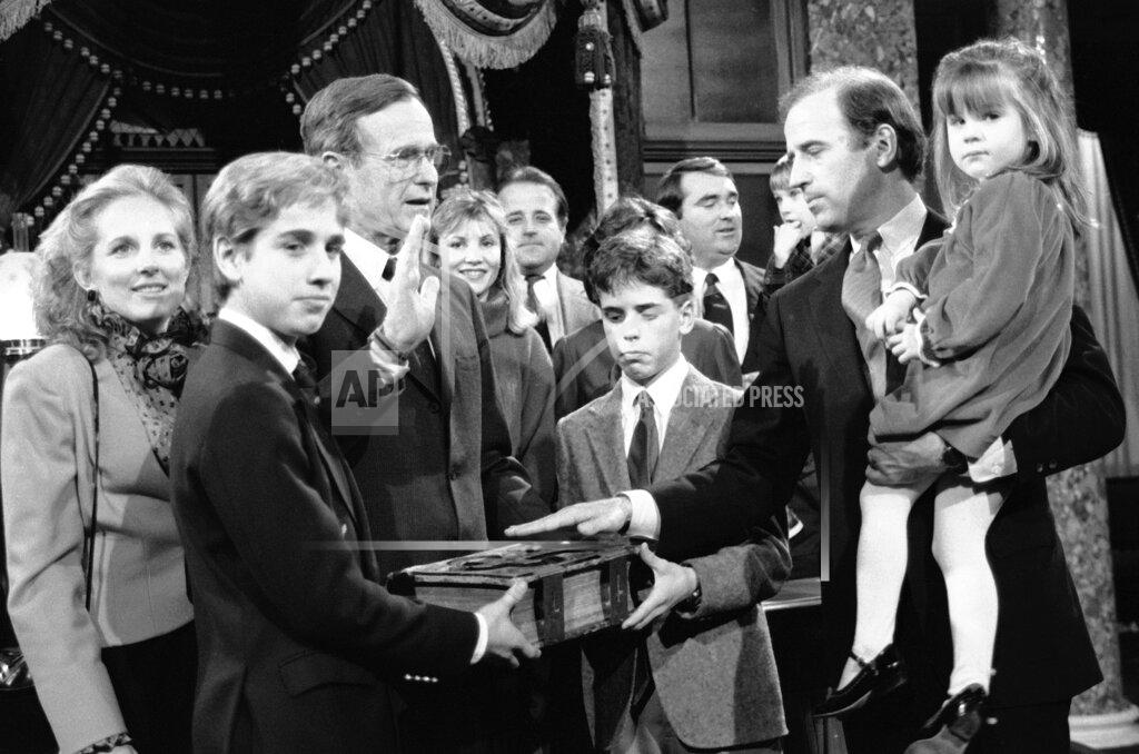 Lana Harris FILE - In this Jan. 3, 1985 file photo, Sen. Joe Biden, D-Del., holds his daughter Ashley while taking a mock oath of office from Vice President George Bush during a ceremony on Capitol Hill, in Washington. Biden's sons Beau and Hunt hold the bible during the ceremony. (AP Photo/Lana Harris, File)
