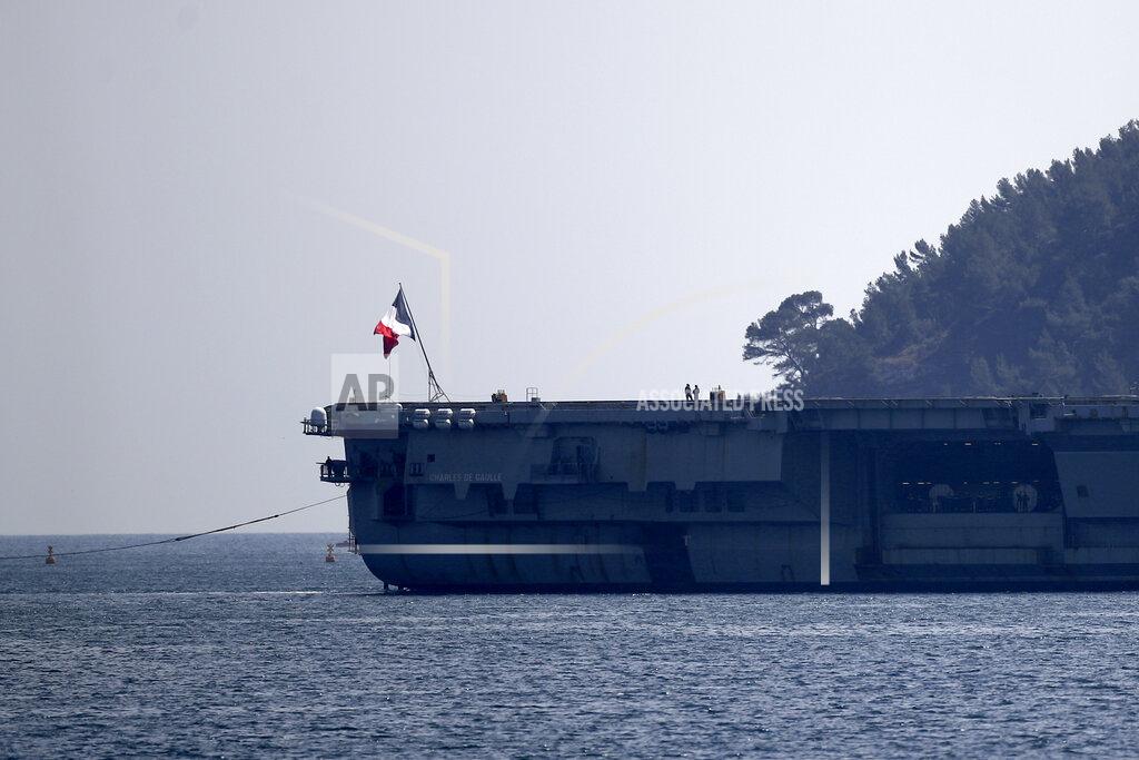 Daniel Cole Sailors stand on the French aircraft carrier Charles de Gaulle in the bay of Toulon, southern France, Sunday April 12, 2020. The Defense Ministry said in a statement that around 40 sailors showed symptoms compatible with COVID-19, the disease the coronavirus causes. The new coronavirus causes mild or moderate symptoms for most people, but for some, especially older adults and people with existing health problems, it can cause more severe illness or death. (AP Photo/Daniel Cole)