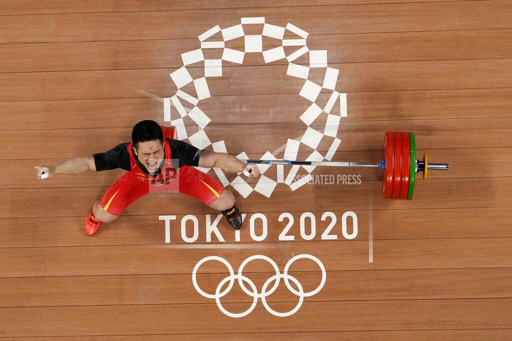 Luca Bruno Shi Zhiyong of China celebrates after winning the gold medal in the men's 73kg weightlifting event, at the 2020 Summer Olympics, Wednesday, July 28, 2021, in Tokyo, Japan. (AP Photo/Luca Bruno)