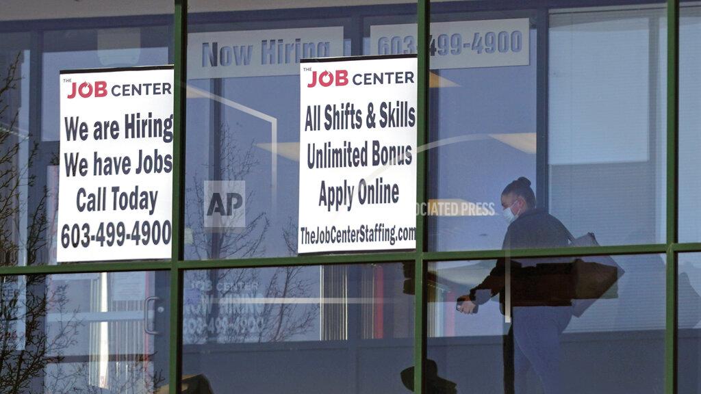 Charles Krupa A woman, wearing a protective mask due to the COVID-19 virus outbreak, walks past the signs of an employment agency, Tuesday, March 2, 2021, in Manchester, N.H. After a year of ghostly airports, empty sports stadiums and constant Zoom meetings, growing evidence suggests that the economy is strengthening. Hiring picked up in February 2021. Business restrictions have eased as the pace of viral infections has ebbed. Yet the economy remains far from normal. (AP Photo/Charles Krupa)