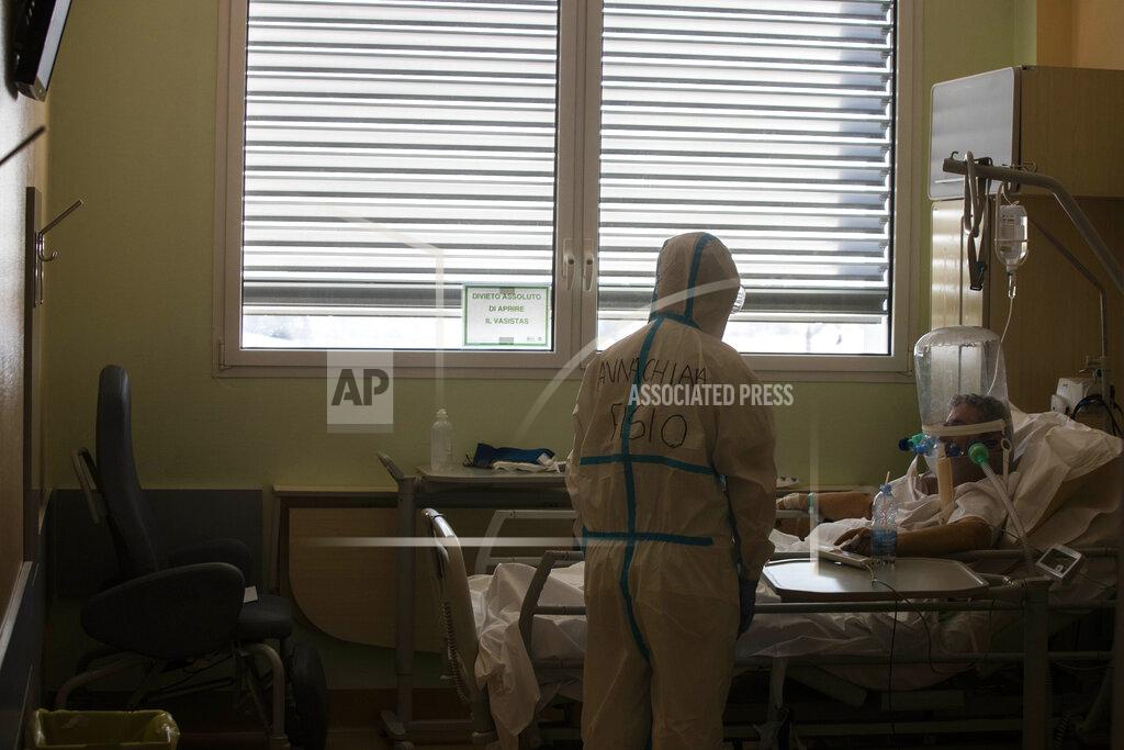 Luca Bruno FILE - In this April 8, 2020 file photo, deputy head of the intensive care unit Flavio Tangian talks with a COVID-19 patient under treatment in the intensive care unit ICU at the Circolo hospital, in Varese, Italy. Italy is poised to reclaim the dishonor of reporting the most coronavirus deaths in Europe, as the second surge ravages the country’s disproportionately old population and exposes how public health shortfalls and delayed restrictions compounded a lack of preparedness going into the pandemic. (AP Photo/Luca Bruno, file)