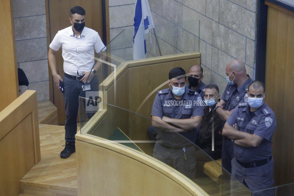 Sebastian Scheiner Yakub Kadari is surrounded by guards in a courtroom in Nazareth, Israel, after he and three other Palestinian fugitives were captured on Saturday, Sept. 11, 2021. Israeli police on Saturday said they have arrested four of the six Palestinians who broke out of a maximum-security prison this week — including a famed militant leader whose exploits over the years have made him a well-known figure in Israel. (AP Photo/Sebastian Scheiner)