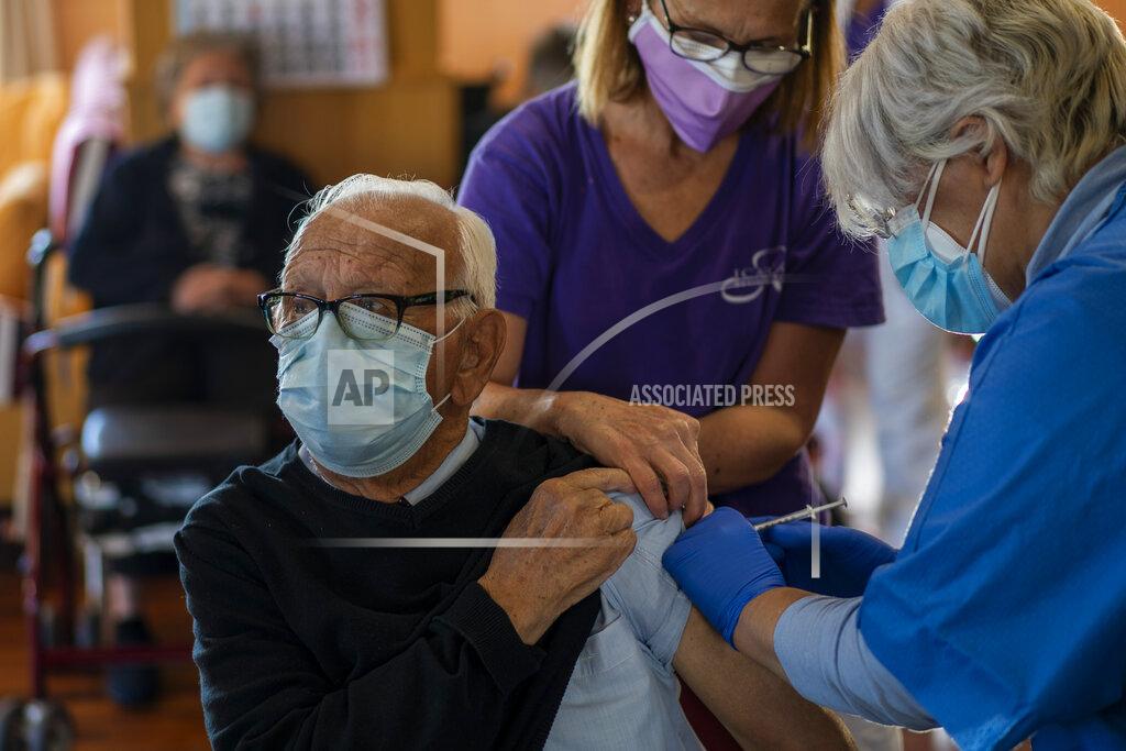 Emilio Morenatti A nurse administers the Pfizer-BioNTech COVID-19 vaccine to a resident at Icaria nursing home in Barcelona, Spain, Tuesday, Jan. 12, 2021. Spain's rate of infection has shot up to 435 cases per 100,000 residents in the past two weeks, prompting new restrictions as authorities try to bring vaccination up to speed. (AP Photo/Emilio Morenatti)