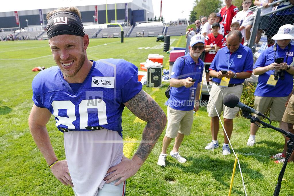 Steven Senne New York Giants tight end Kyle Rudolph, left, steps away from a microphone after facing reporters following a joint NFL football practice with the New England Patriots, Wednesday, Aug. 25, 2021, in Foxborough, Mass. (AP Photo/Steven Senne)