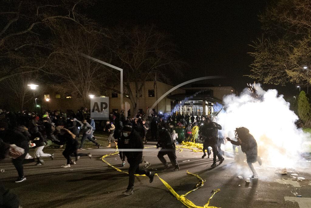 Carlos Gonzalez People run as police attempt to disperse the crowd at the Brooklyn Center Police Department, late Sunday, April 11, 2021, in Brooklyn Center, Minn. The family of Daunte Wright, 20, told a crowd that he was shot by police Sunday before getting back into his car and driving away, then crashing the vehicle several blocks away. The family said Wright was later pronounced dead. (Carlos Gonzalez/Star Tribune via AP)