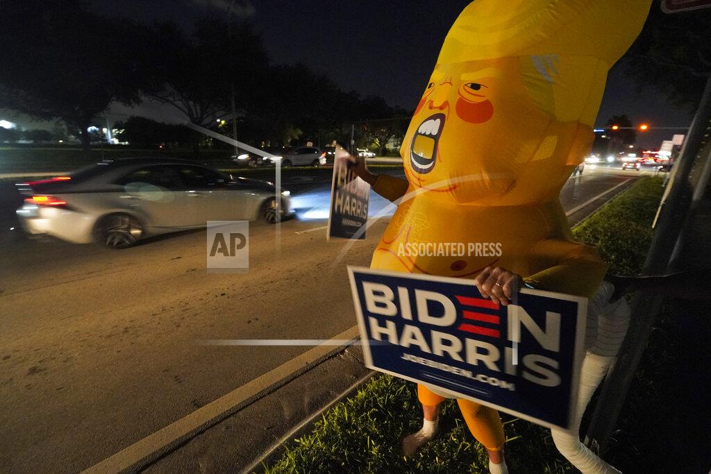 Wilfredo Lee Wearing an inflatable Baby Trump costume, Bob Remmen chants, "Baby Trump says vote for Joe Biden", Tuesday, Nov. 3, 2020, outside the Miami-Dade County Elections Department in Doral, Fla. (AP Photo/Wilfredo Lee)