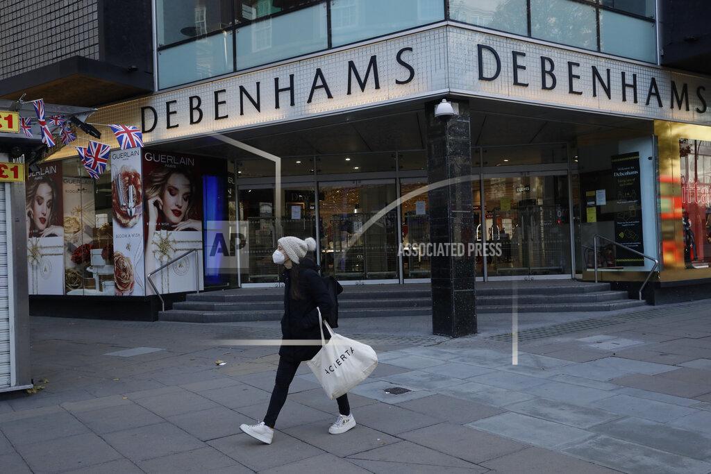 Matt Dunham A woman wearing a face mask walks past the Debenhams flagship department store on Oxford Street, during England's second coronavirus lockdown in London, Tuesday, Dec. 1, 2020. In another dark day for the British retailing industry, Debenhams said Tuesday it will start liquidating its business after a potential buyer of the company pulled out, a move that looks like it will cost 12,000 workers their jobs. (AP Photo/Matt Dunham)