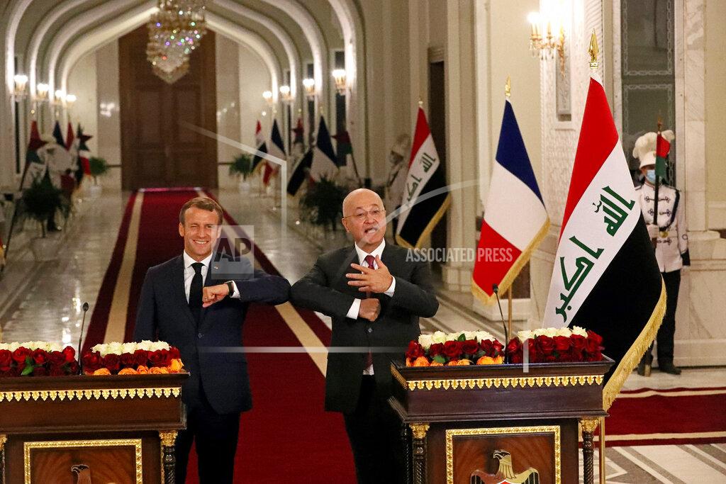 Khalid Mohammed French President Emmanuel Macron, left, and Iraqi President Barham Salihat, elbow bump during a news conference at the presidential palace, in Baghdad, Iraq, Wednesday, Sept. 2, 2020. Macron is the first head of state to visit the Iraqi capital since the country's new prime minister and Iraq’s former intelligence chief formed a government in May. (AP Photo/Khalid Mohammed)