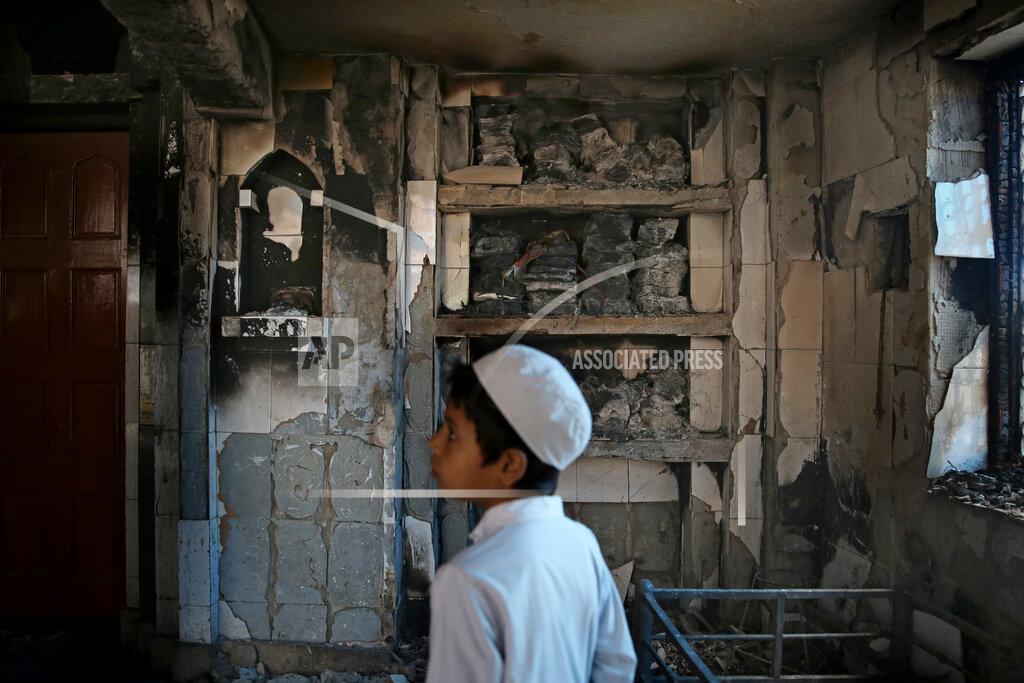 Altaf Qadri FILE - In this Thursday, Feb. 27, 2020, file photo, an Indian Muslim boy stands inside a mosque burnt in Tuesday's communal violence in New Delhi, India. As the first anniversary of bloody communal riots that convulsed the Indian capital approaches, Muslim victims are still shaken and struggling to make sense of their struggle to seek justice. Many say they have run repeatedly into a refusal by police to investigate complaints made by Muslims against Hindu rioters. (AP Photo/Altaf Qadri)