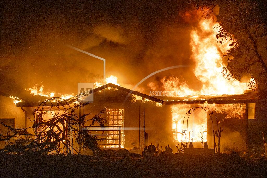 Ethan Swope FILE - In this Sept. 27, 2020, file photo, a house burns on Platina Road at the Zogg Fire near Ono, Calif. California power regulators are poised to reprimand Pacific Gas and Electric for continuing to neglect its electrical grid that has ignited a series of deadly wildfires in Northern California and could order the utility to do be more vigilant in the upcoming months of hot, windy weather. The anticipated rebuke from the California Public Utilities Commission Thursday, April 15, 2021, would serve as official notice to PG&E that it hasn't been doing enough to reduce the risks posed by a combination of crumbling equipment and overgrown trees susceptible to touching or toppling into nearby power lines. (AP Photo/Ethan Swope, File)