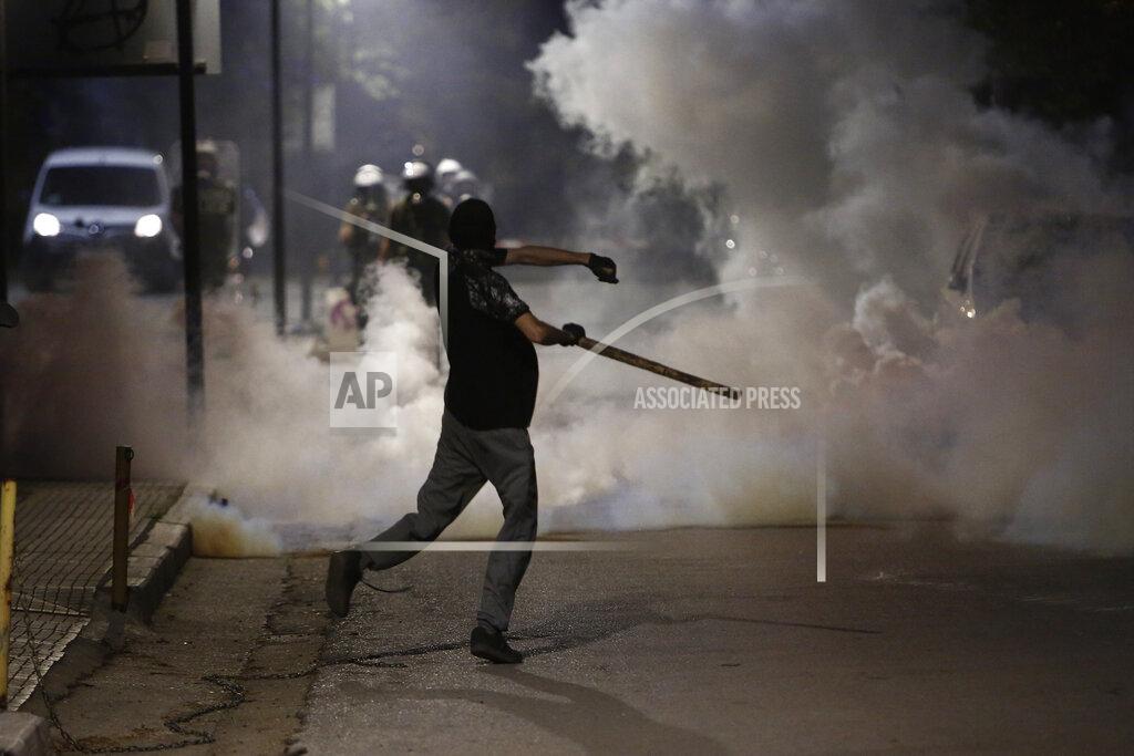 Giannis Papanikos A protester throws a stone towards police forces during a rally in the northern Greek city of Thessaloniki, Greece, Thursday, May 26, 2022. Earlier Thursday, the protesters faced off with police inside the city's main university campus, where unrest has been bubbling for weeks over a left-wing squat that was closed down. (AP Photo/Giannis Papanikos)
