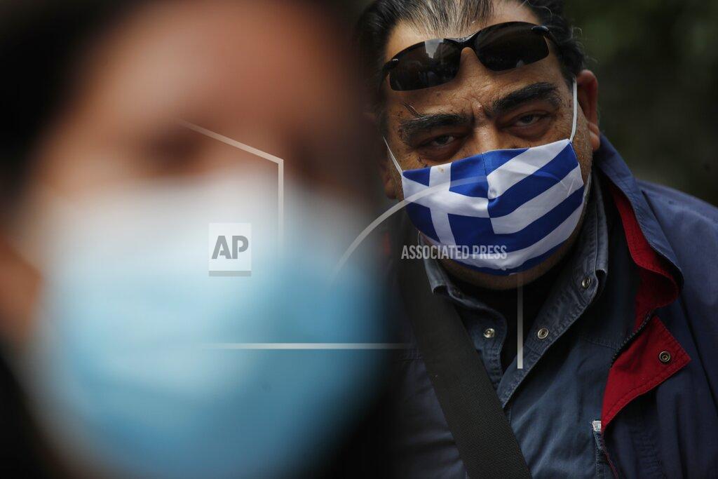 Thanassis Stavrakis A retired health worker wearing a face mask with the Greek flag, takes part in a protest at Evangelismos hospital in Athens, Thursday, Nov. 12, 2020. State health workers' union staged protests at several hospitals around the country to demand more hiring. Greece has imposed a nationwide nightly curfew as the number of COVID-19 cases in the country continues to surge despite a lockdown. (AP Photo/Thanassis Stavrakis)