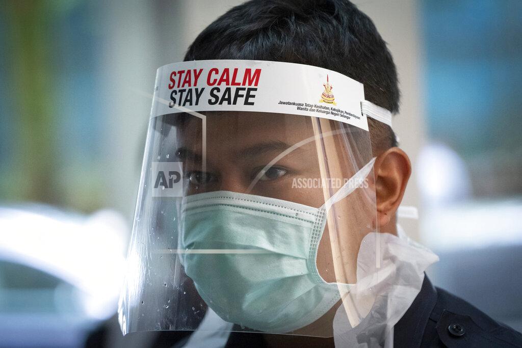 Vincent Thian A healthcare staff member looks on as he arranges for residents to collect samples for coronavirus testing at an urban area in Bandar Utama, outskirts of Kuala Lumpur, Malaysia Thursday, Oct. 22, 2020. Malaysia restrict movements in its biggest city Kuala Lumpur, neighboring Selangor state and the administrative capital of Putrajaya from Wednesday in an attempt to curb a sharp rise in coronavirus cases. (AP Photo/Vincent Thian)