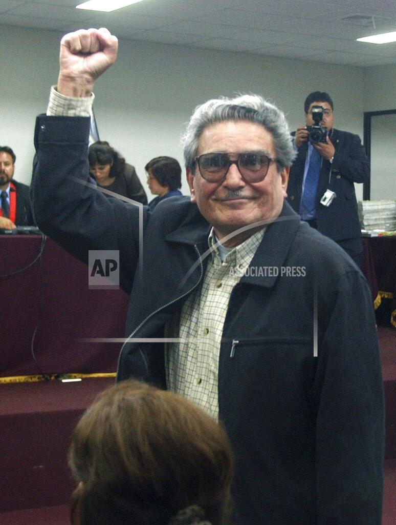 Martin Mejia FILE - In this in this Nov. 5, 2004 file photo, Abimael Guzman, the founder and former leader of the Shining Path guerrilla movement, raises his arm during the first day of his civilian trial at the Naval Base in Callao, Peru. The Peruvian government reported Saturday, Sept. 11, 2021, that Guzman died after an illness. (AP Photo/Martin Mejia, File)