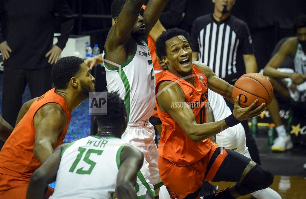 Andy Nelson Oregon State guard Gianni Hunt (0) drives to the basket past Oregon forward Eugene Omoruyi (2) during the first half of an NCAA college basketball game Saturday, Jan. 23, 2021, in Eugene, Ore. (AP Photo/Andy Nelson)