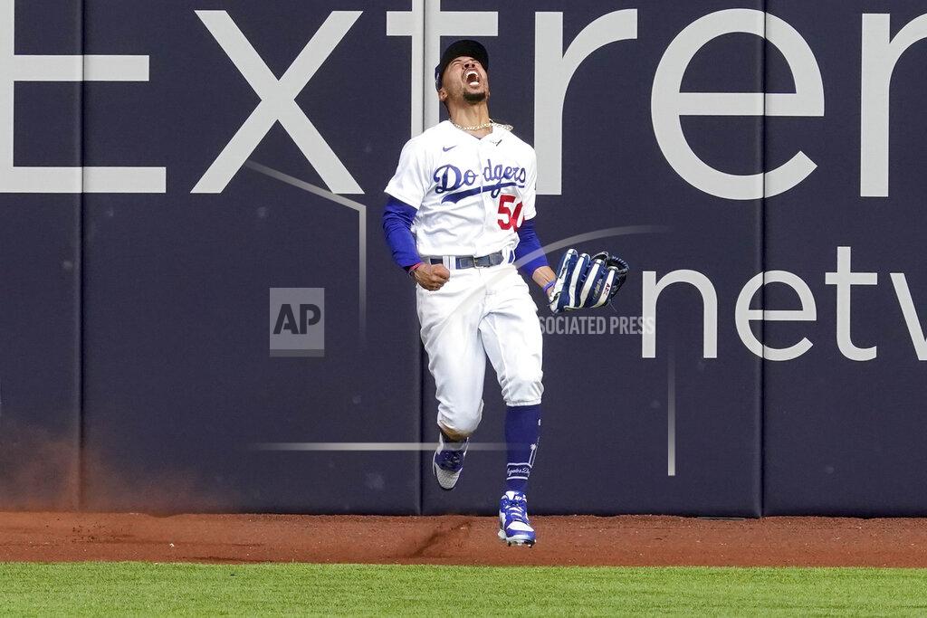 Tony Gutierrez Los Angeles Dodgers right fielder Mookie Betts celebrates after robbing Atlanta Braves' Marcell Ozuna of a home during the fifth inning in Game 6 of a baseball National League Championship Series Saturday, Oct. 17, 2020, in Arlington, Texas. (AP Photo/Tony Gutierrez)