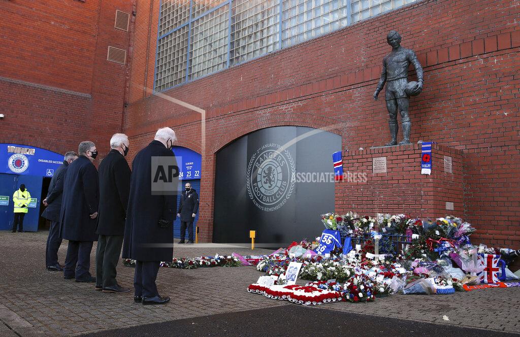 Andrew Milligan John Greig, Celtic chairman Ian Bankier and Rangers chairman Douglas Park lay wreaths outside the stadium in front of the statue of John Greig on the 50th anniversary of the Ibrox disaster ahead of the Scottish Premiership match between Rangers and Celtic at Ibrox Stadium, Glasgow, Saturday Jan. 2, 2021. The anniversary marks 50 years since the disaster at the stadium which claimed the lives of 66 people. The fans were crushed on a stairway when barriers collapsed at the Glasgow venue. (Andrew Milligan/PA via AP)
