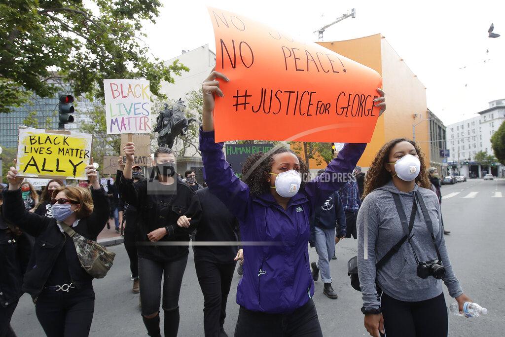 Jeff Chiu People march toward City Hall during a protest over the Memorial Day death of George Floyd, a handcuffed black man in police custody in Minneapolis, in San Francisco, Saturday, May 30, 2020. (AP Photo/Jeff Chiu)