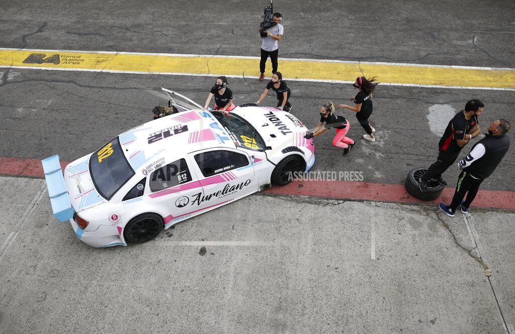 Natacha Pisarenko Vitarti Girl’s Team mechanics, from left, Paula Salazar, Agustina Carreira, team Director Tamara Vital, and mechanic Victoria Pascual push their racing car with driver Karina Dobal at the wheel into pits after the team's first race at the Oscar y Juan Galvez track in Buenos Aires, Argentina, Sunday, April 4, 2021. The Vitarti Girl's Team is comprised of a director, engineers, mechanics and drivers, all women, and started competing in April in the Top Race Junior series. (AP Photo/Natacha Pisarenko)