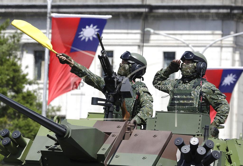 Chiang Ying-Ying FILE - In this Oct. 10, 2021, file photo, Taiwanese soldiers salute during National Day celebrations in front of the Presidential Building in Taipei, Taiwan. After sending a record number of military aircraft to harass Taiwan over China’s National Day holiday weekend, Beijing has toned down the sabre rattling but tensions remain high, with the rhetoric and reasoning behind the exercises unchanged. (AP Photo/Chiang Ying-ying, File)