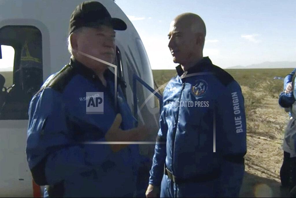 Uncredited In this image provided by Blue Origin, William Shatner talks with Jeff Bezos about his experience after exiting the Blue Origin capsule near Van Horn, Texas, Wednesday, Oct. 13, 2021. The “Star Trek” actor and three fellow passengers hurtled to an altitude of 66.5 miles (107 kilometers) over the West Texas desert in the fully automated capsule, then safely parachuted back to Earth in a flight that lasted just over 10 minutes. (Blue Origin via AP)