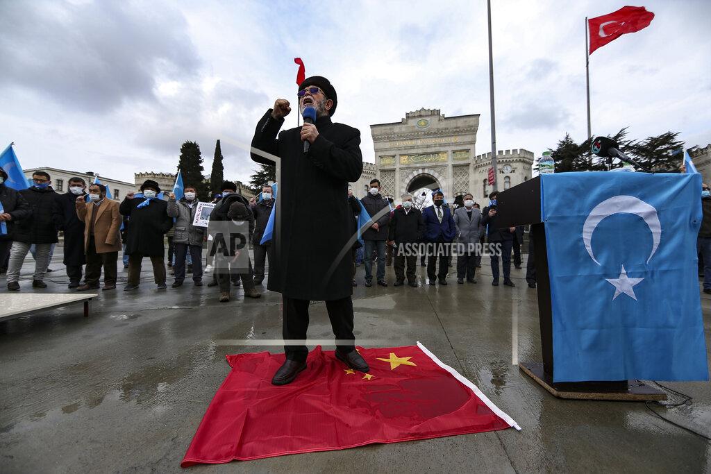 Emrah Gurel A protester from the Uyghur community living in Turkey steps on a China flag and delivers a speech during a protest against the visit of China's Foreign Minister Wang Yi to Turkey, in Istanbul, Thursday, March 25, 2021. Hundreds of Uyghurs staged protests in Istanbul and the capital Ankara, denouncing Wang Yi's visit to Turkey and demanding that the Turkish government take a stronger stance against human rights abuses in China's far-western Xinjiang region. (AP Photo/Emrah Gurel)
