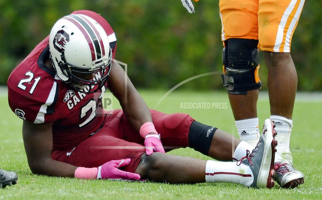 Richard Shiro FILE - In this Oct. 27, 2012, file photo, South Carolina running back Marcus Lattimore grabs his right knee after getting hit by Tennessee's Eric Gordon during the first half of an NCAA college football game at Williams-Brice Stadium in Columbia, S.C. Lattimore’s task these days comes away from the field in helping the Gamecocks handle the stresses of major college football and prepare for life when the games are over. Few know better than Lattimore, 27, how things can change for a can’t-miss NFL prospect. (AP Photo/Richard Shiro, File)