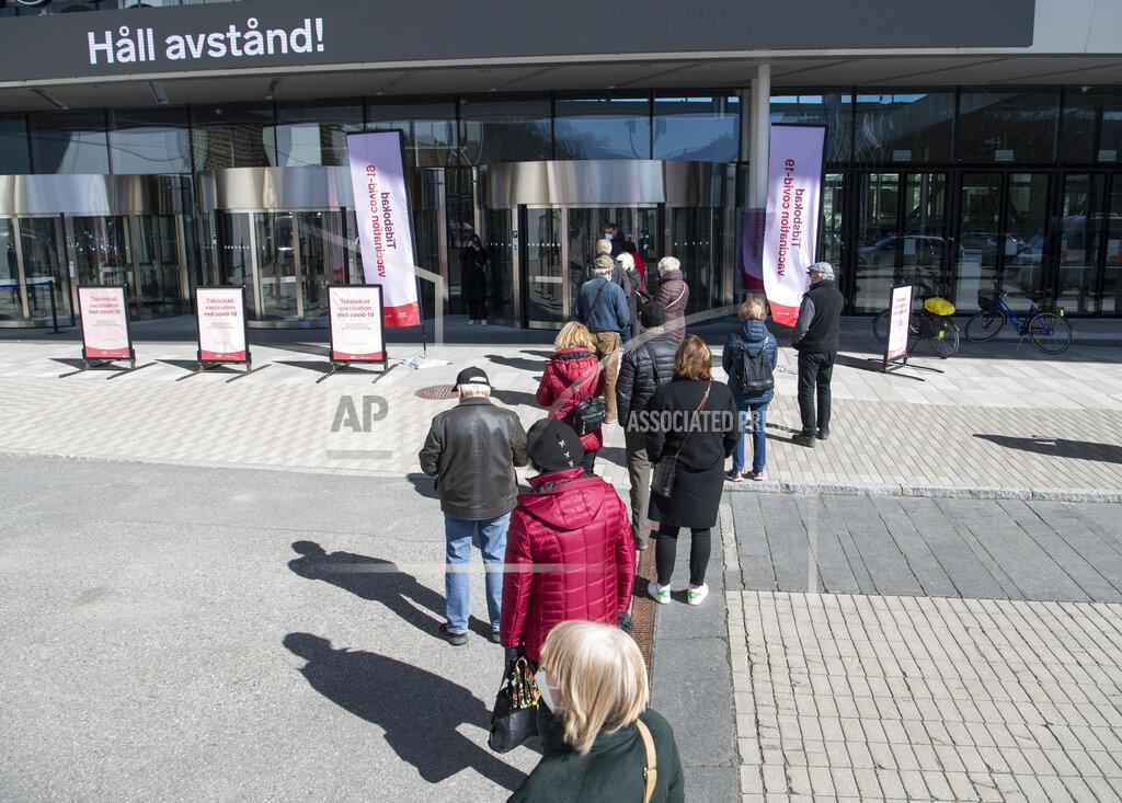 Fredrik Sandberg People queue to receive a COVID-19 vaccine, outside the Stockholmsmassan exhibition center turned mass vaccination center, in Stockholm, Sweden, Thursday April 8, 2021. (Fredrik Sandberg/TT News Agency via AP)