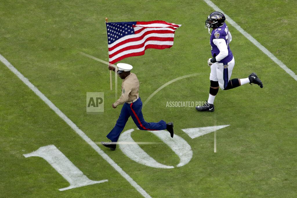 Julio Cortez Baltimore Ravens offensive tackle Ronnie Stanley (79) runs with a U.S. service member as part of the team's Salute to Service prior to an NFL football game against the Houston Texans, Sunday, Nov. 17, 2019, in Baltimore. (AP Photo/Julio Cortez)