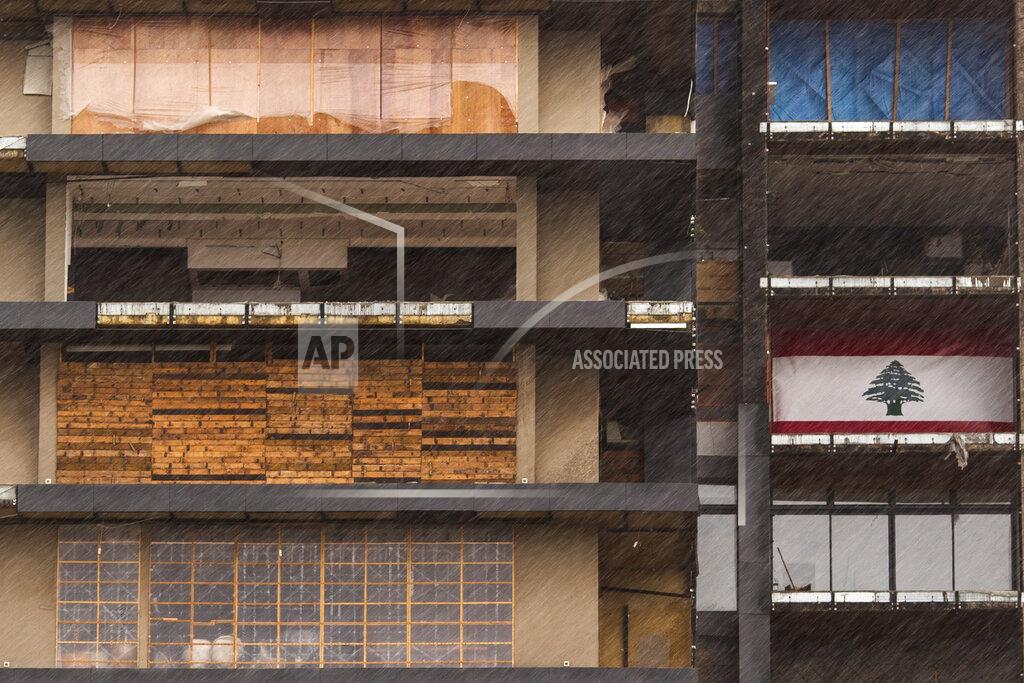 Hassan Ammar Windows and doors of a building that were damaged in the Aug. 4 explosion in Beirut's port are covered with various materials against the cold and rain, in Beirut, Lebanon, Wednesday, Feb. 17, 2021. Storm Joyce hit late Tuesday with gale force winds registering up to 100 km/h (62 miles/h). (AP Photo/Hassan Ammar)
