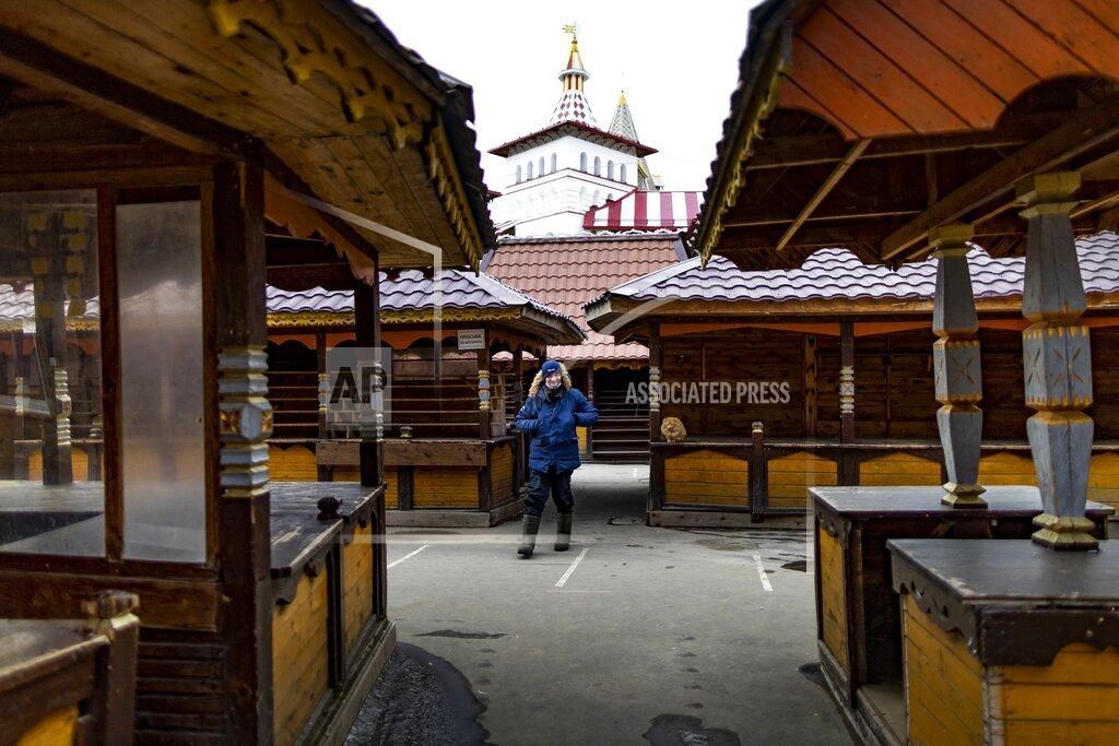 Alexander Zemlianichenko A security worker walks through an empty market near a boutique hotel called Skazka – or "Fairytale" -- in eastern Moscow on Tuesday, March 23, 2021. One year later, Skazka is still open — thanks to some creative thinking by its owners — but with many fewer guests than before the pandemic. (AP Photo/Alexander Zemlianichenko)