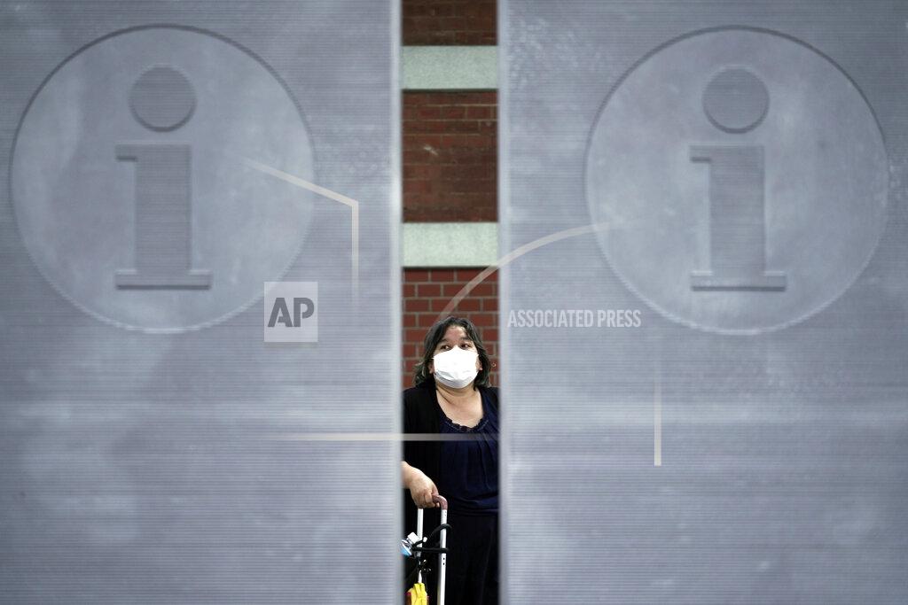 Eugene Hoshiko A woman wearing a face mask to help curb the spread of the coronavirus walks Monday, July 13, 2020, in Tokyo. The Japanese capital has confirmed more than 100 new coronavirus infections on Monday. (AP Photo/Eugene Hoshiko)